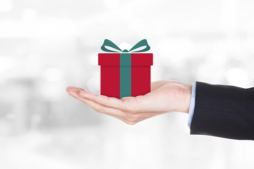 Businessman hands holding gift box on blur gray background