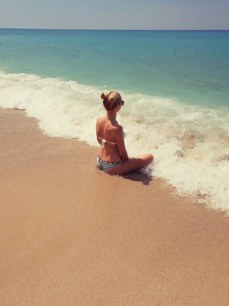 istock The girl sits on the seashore 1127141956