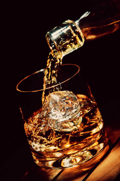 pouring a glass of whiskey on ice - whisky glass alcohol drink imagens e fotografias de stock