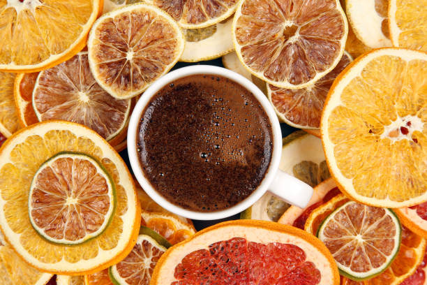 Black coffee in a white Cup surrounded by citrus dried fruits