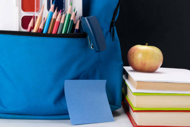 istock a school backpack with colored paints in a pocket is on the table next to an apple 1127147776