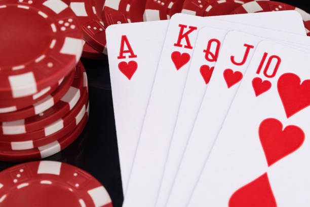 istock red poker chips and playing cards concept on black background close up 1127147822