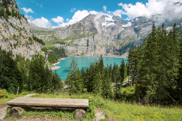 Oeschinensee in the Swiss Alps A bench overlooking Oeschinensee in the Swiss Alps lake oeschinensee stock pictures, royalty-free photos & images