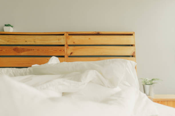 istock Loft style unmaking bed with wooden headboard. 1127151069