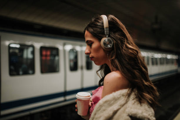 istock Young woman with headphones inside subway station platform 1127151556