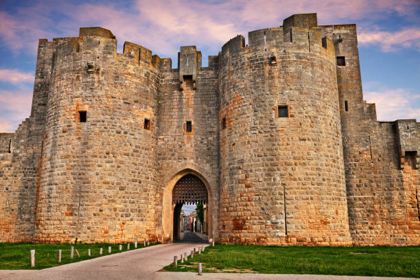 Aigues-Mortes, Gard, Occitania, France: the city gate in the medieval walls Aigues-Mortes, Gard, Occitania, France: the ancient city gate between the ramparts of the walls im the medieval town of Camargue city gate stock pictures, royalty-free photos & images