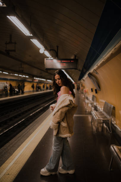 istock Young woman on a bench inside an underground station platform 1127151583