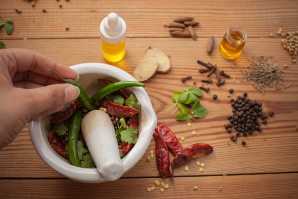 close-up of hands preparing spices in mortar and pestle. - mortar and pestle spice seasoning coriander seed imagens e fotografias de stock