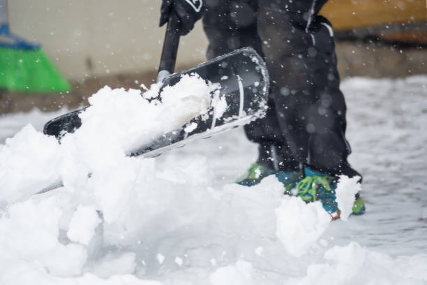 Someone is  shoveling snow outside in winter while it is snowing stock photo