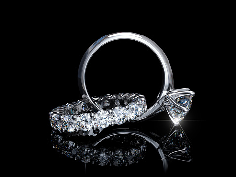Entretejido de diamante anillo de compromiso, anillo de bodas sobre fondo negro photo