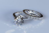 Diamond engagement ring, wedding ring on blue glossy background