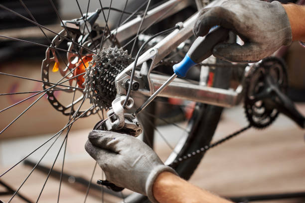istock Male mechanic working in bicycle repair shop using tools 1127154940
