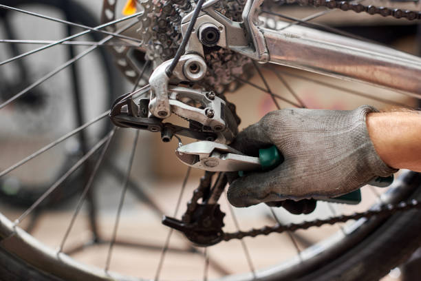 istock Male mechanic working in bicycle repair shop using tools 1127154950