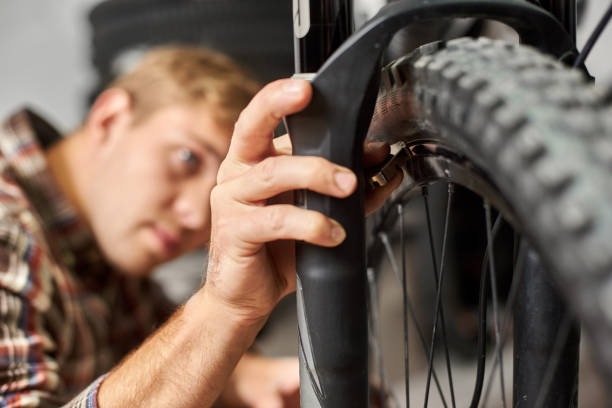 istock Male mechanic working in bicycle repair shop using tools 1127154962