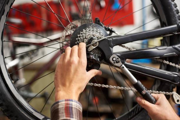 istock Male mechanic working in bicycle repair shop using tools 1127154966
