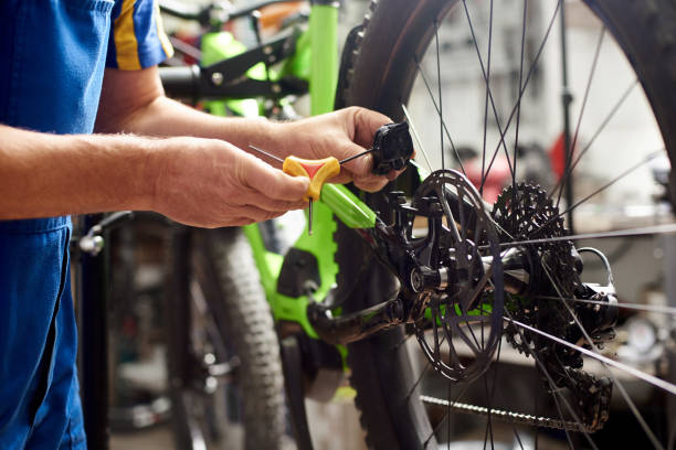 istock Male mechanic working in bicycle repair shop using tools 1127154971