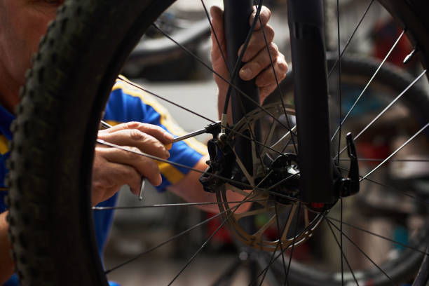 istock Male mechanic working in bicycle repair shop using tools 1127155455