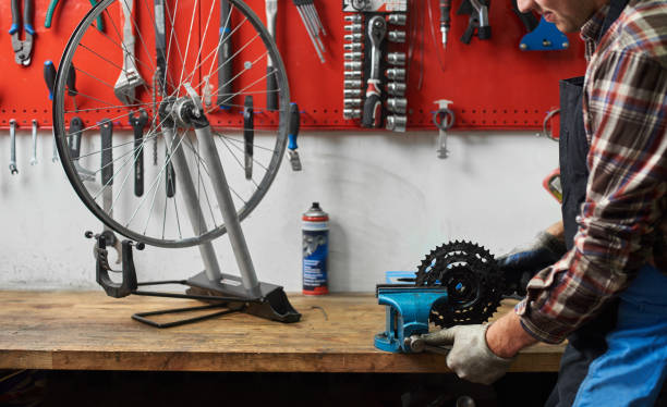 istock Male mechanic working in bicycle repair shop using tools 1127155484