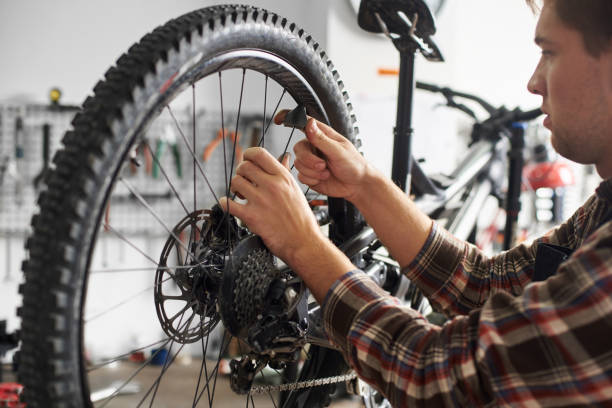 istock Male mechanic working in bicycle repair shop using tools 1127155497