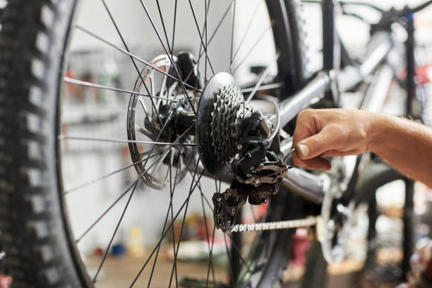 istock Male mechanic working in bicycle repair shop using tools 1127155498
