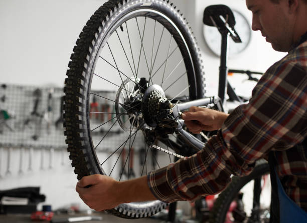 istock Male mechanic working in bicycle repair shop using tools 1127155502