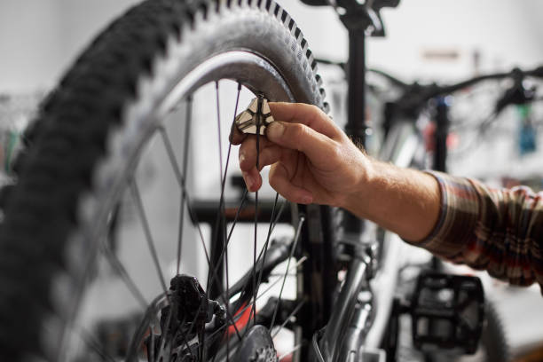 istock Male mechanic working in bicycle repair shop using tools 1127155503