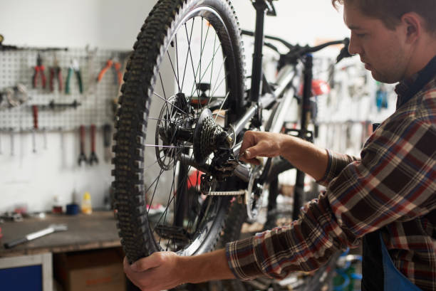 istock Male mechanic working in bicycle repair shop using tools 1127155509