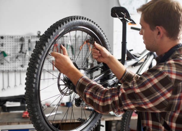 istock Male mechanic working in bicycle repair shop using tools 1127155516
