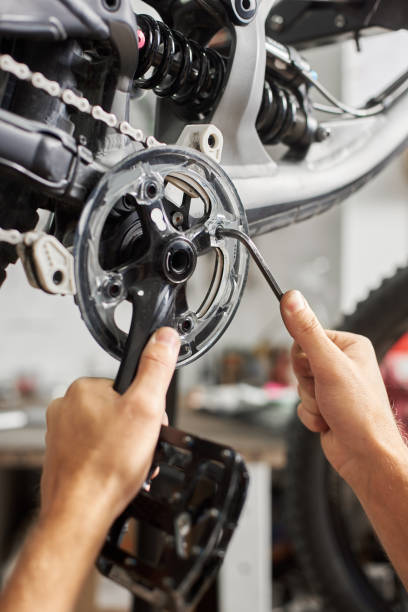 istock Male mechanic working in bicycle repair shop using tools 1127155527