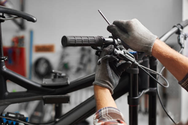 istock Male mechanic working in bicycle repair shop using tools 1127155531