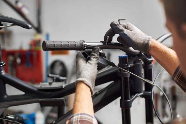 istock Male mechanic working in bicycle repair shop using tools 1127155534