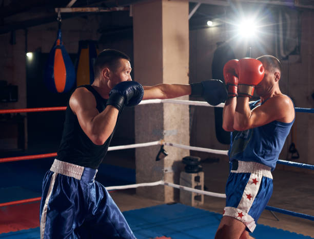 boxers training kickboxing in the ring at the health club - boxing combative sport defending protection imagens e fotografias de stock