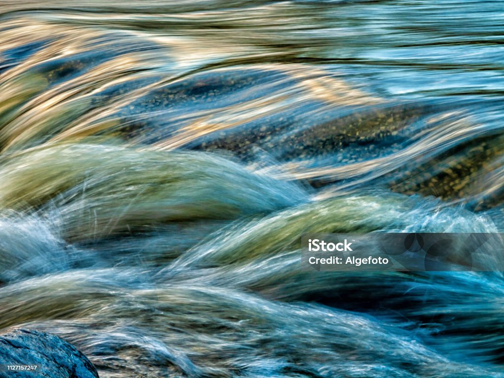 motion blurred water stream Close-up of a motion blurred mountain Stream Water Stock Photo