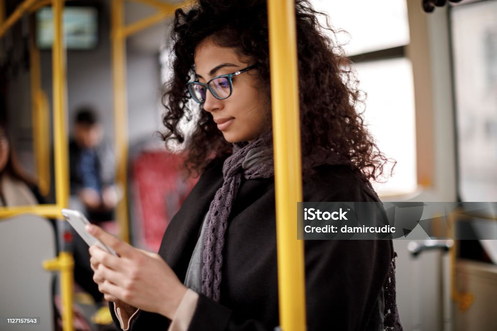 Young woman traveling by bus and using smart phone Bus Stock Photo