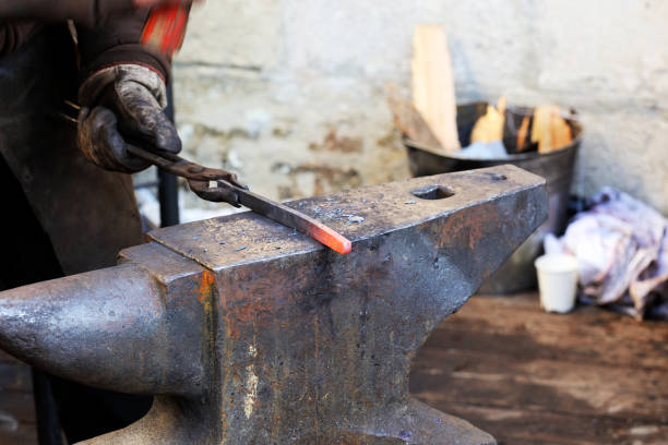 istock Blacksmith working metal with hammer on the anvil 1127157768