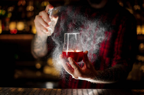 istock Bartender sprinkling bitter into the glass with red sweet cocktail 1127159607