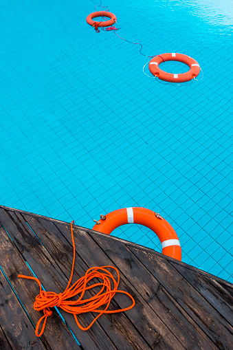 Orange color life preservers floating in swimming pool in Greece.