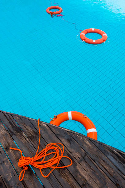 orange color life preservers floating in swimming pool in greece - nobody inflatable equipment rope imagens e fotografias de stock