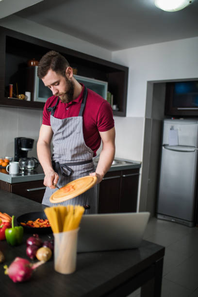 istock Cooker man chopping carrot on kitchen board. 1127160439