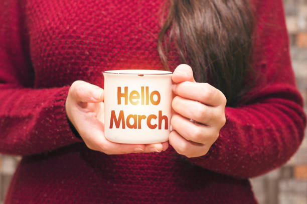 istock hello march text on cup and woman drinking a coffee 1127160529
