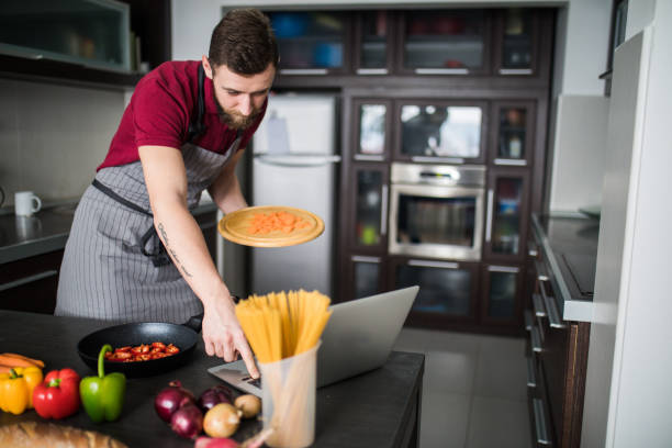 istock Man looking recipe on laptop in kitchen at home 1127160617