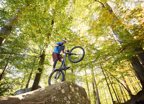istock Sportsman cyclist balancing on back wheel on trial bicycle 1127160633