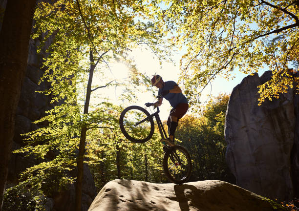 istock Sportsman cyclist balancing on back wheel on trial bicycle 1127160635