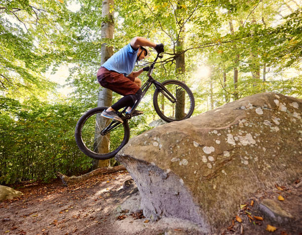 istock Sportsman cyclist balancing on back wheel on trial bicycle 1127160636