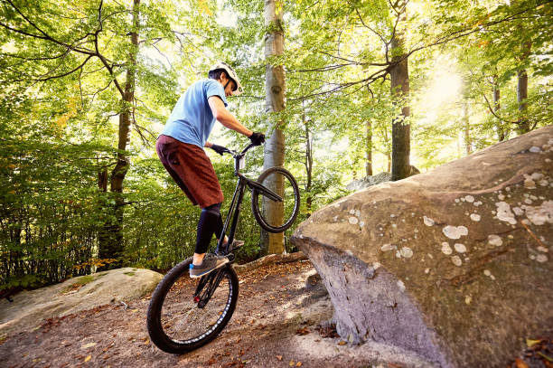 istock Sportsman cyclist balancing on back wheel on trial bicycle 1127160644