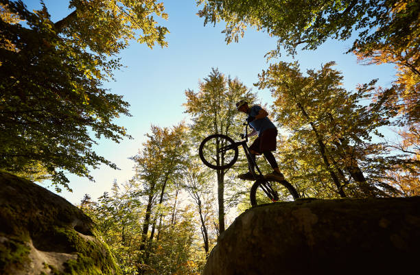 istock Sportsman cyclist balancing on back wheel on trial bicycle 1127160647