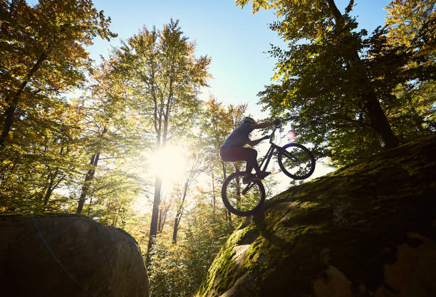 Sportsman cyclist balancing on back wheel on trial bicycle