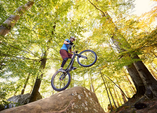 istock Sportsman cyclist balancing on back wheel on trial bicycle 1127160652
