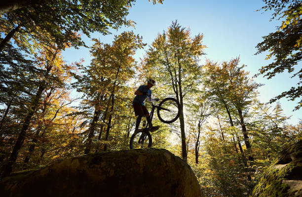 istock Sportsman cyclist balancing on back wheel on trial bicycle 1127160654