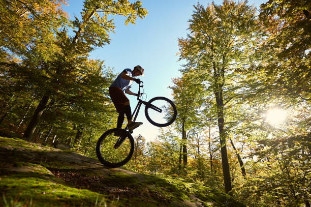 istock Sportsman cyclist balancing on back wheel on trial bicycle 1127160660
